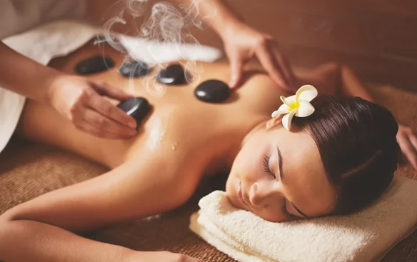 Praticienne effectuant un massage relaxant aux pierres chaudes à Uccle